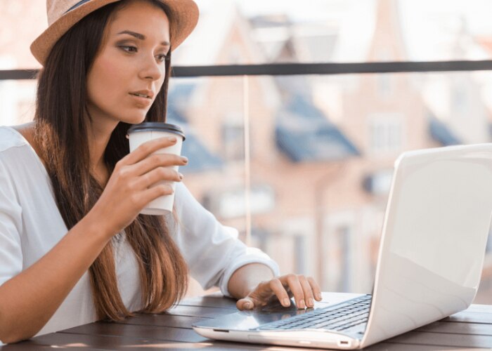 woman with laptop drinks coffee