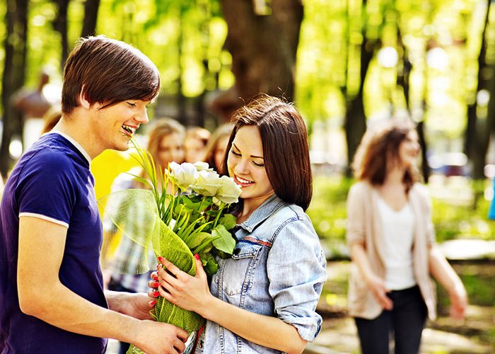 guy gives white roses to woman